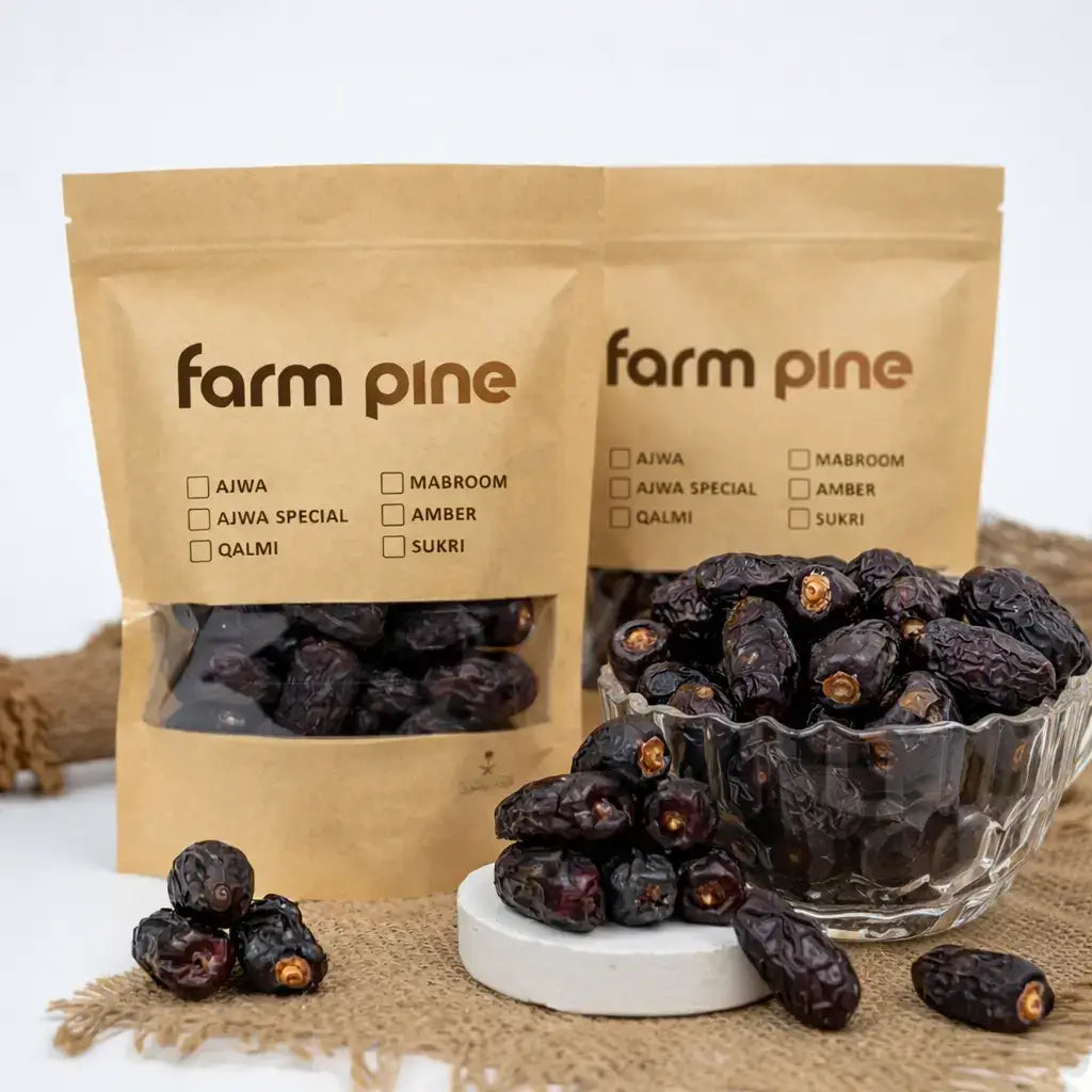 Dried dates in a glass bowl with 'farm pine' packaging on a white background